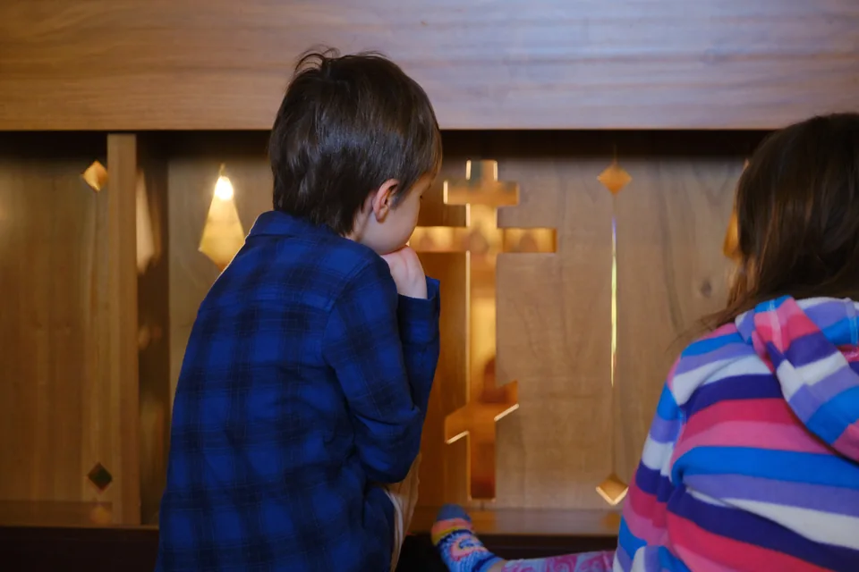 Children peering through the balcony railing during Liturgy